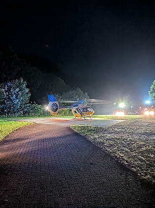 Hubschrauber landet auf einem ausgeleuchteten Landeplatz