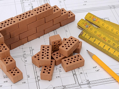 Bausteine und Zollstock auf Bauplan