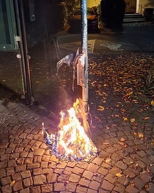 Ein brennender Mülleimer an einer Bushaltestelle