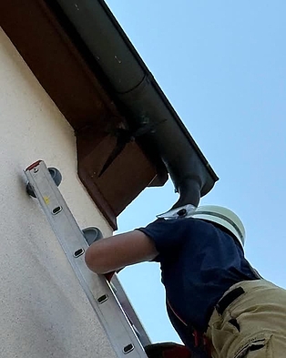 Feuerwehrmann auf Leiter an ein Haus gelehnt