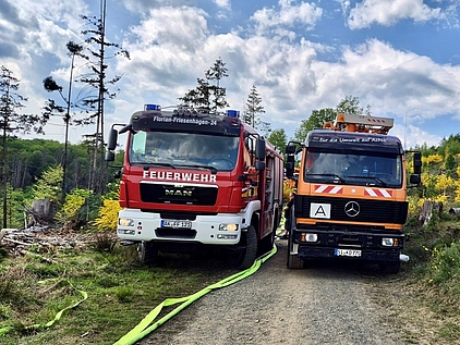 Feuerwehr- und Entsorgungsfahrzeug auf einem Waldweg